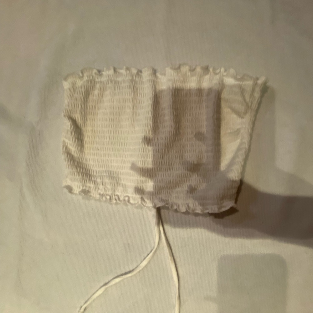 white tube top opened from the back with adjustable strings .